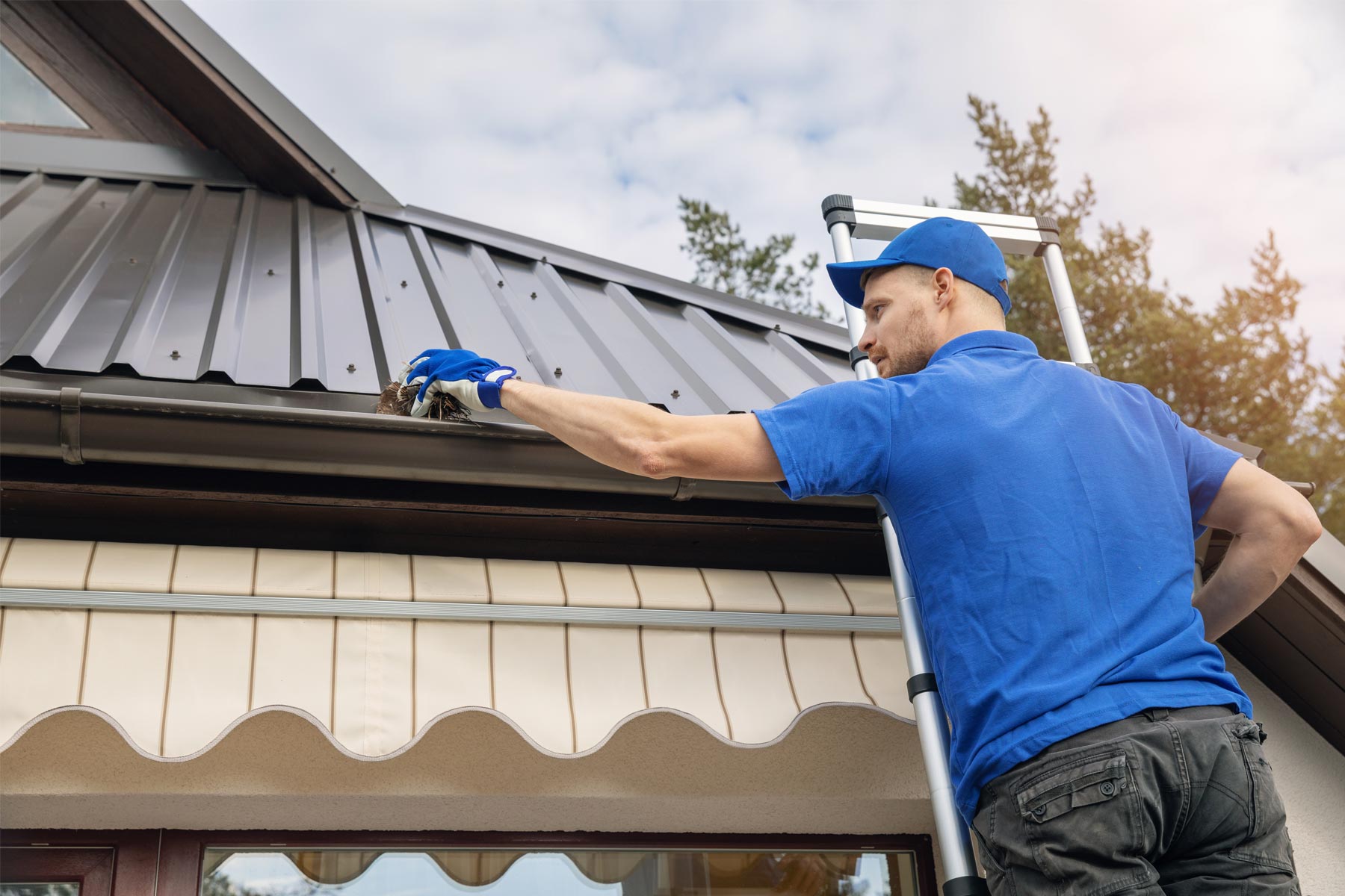 home repair expert from Handyman Connection cleaning a gutter